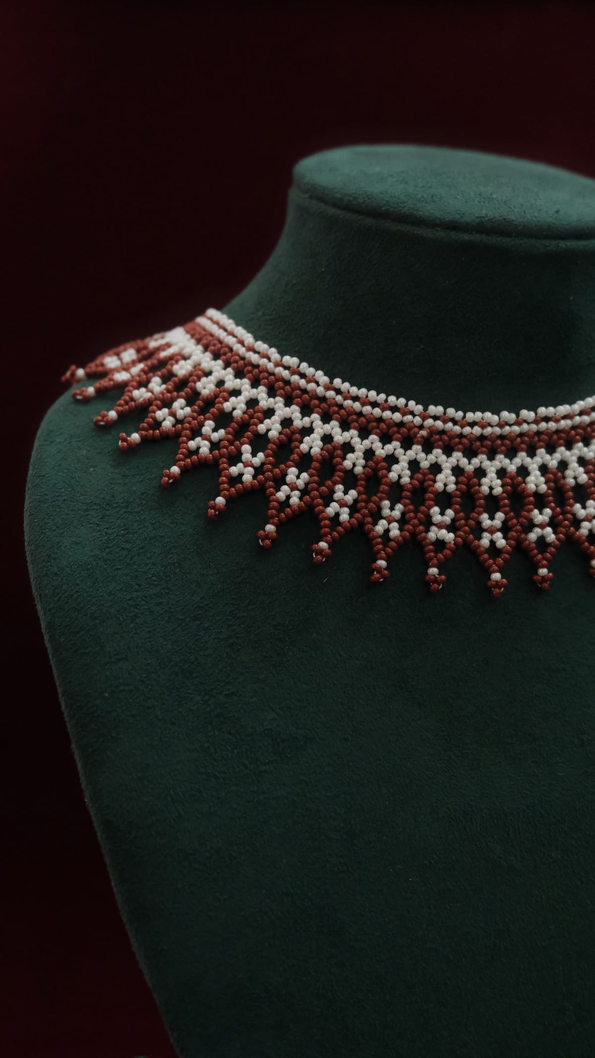 A close view of the netting stitch: glass beads worked into diamonds, finished with a row of picot points.